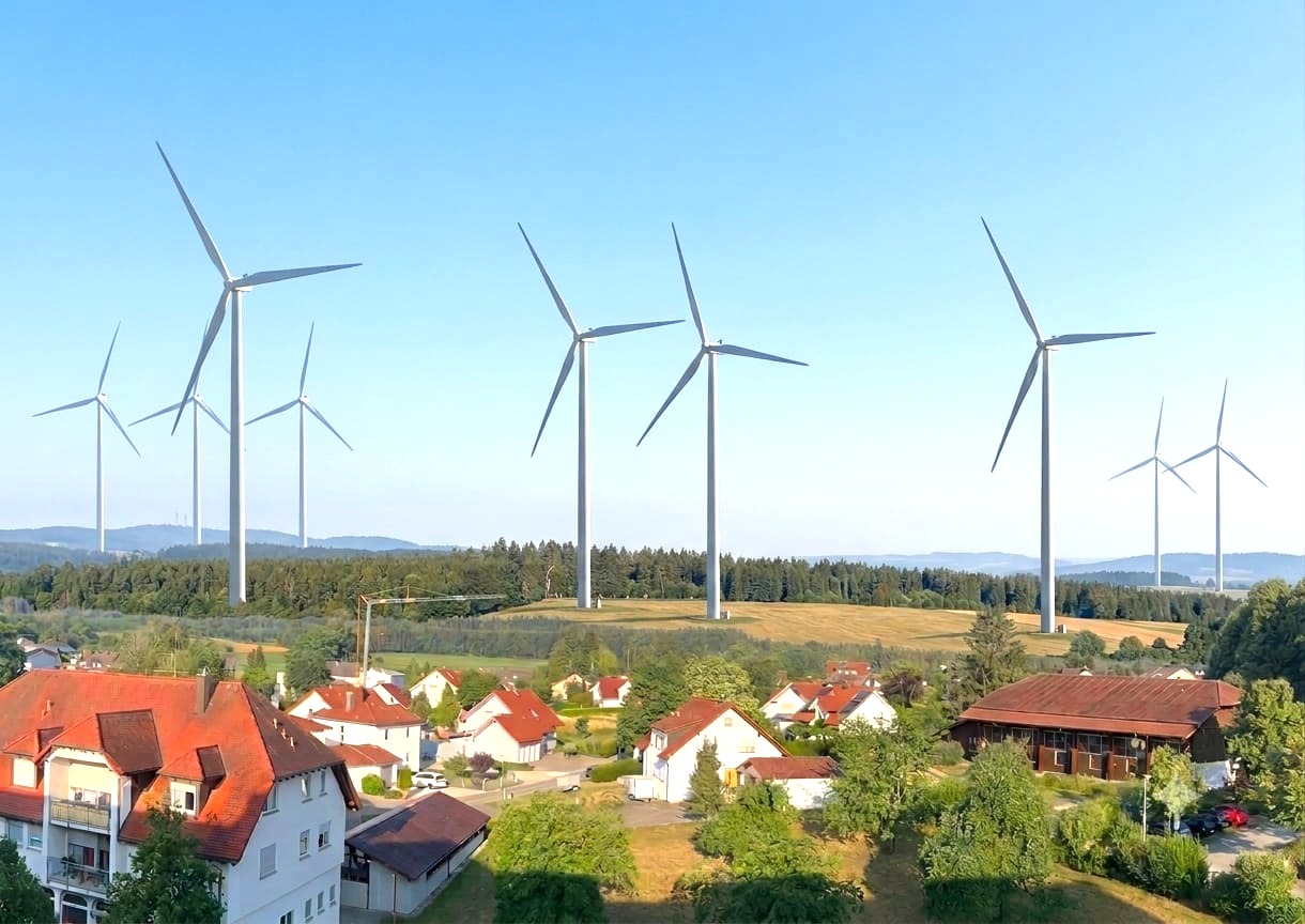 Fotomontage mit nachträglich eingefügten Windrädern über dem Dorf