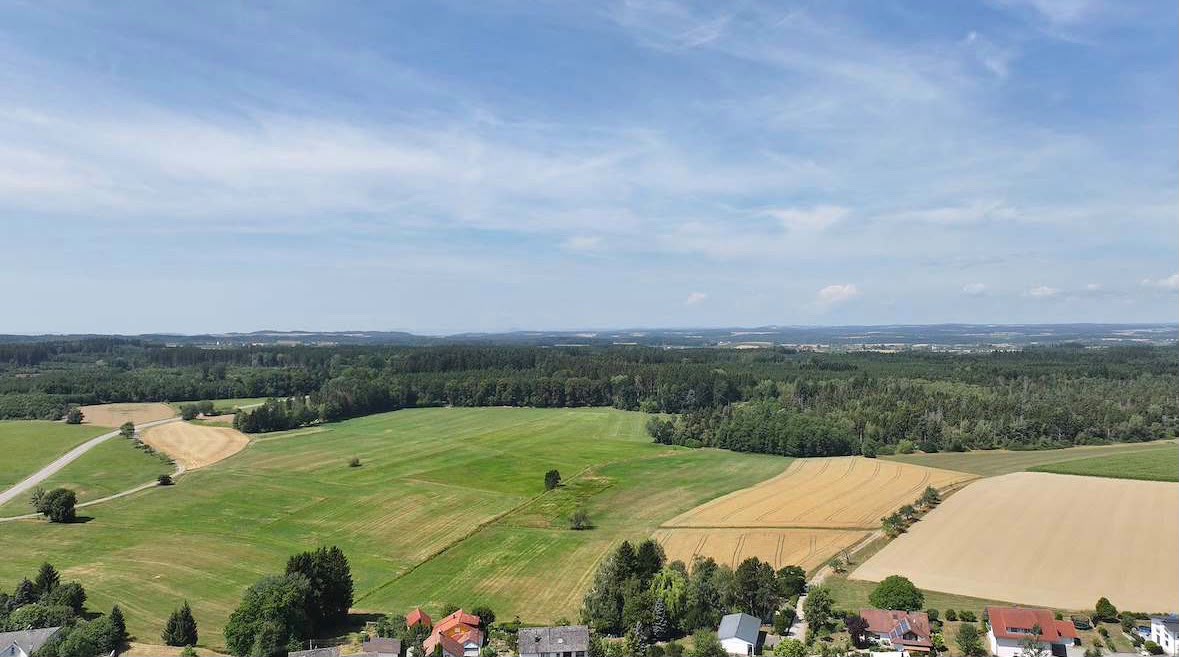 Luftaufnahme der Feldflur zwischen Ortschaft und Wald
